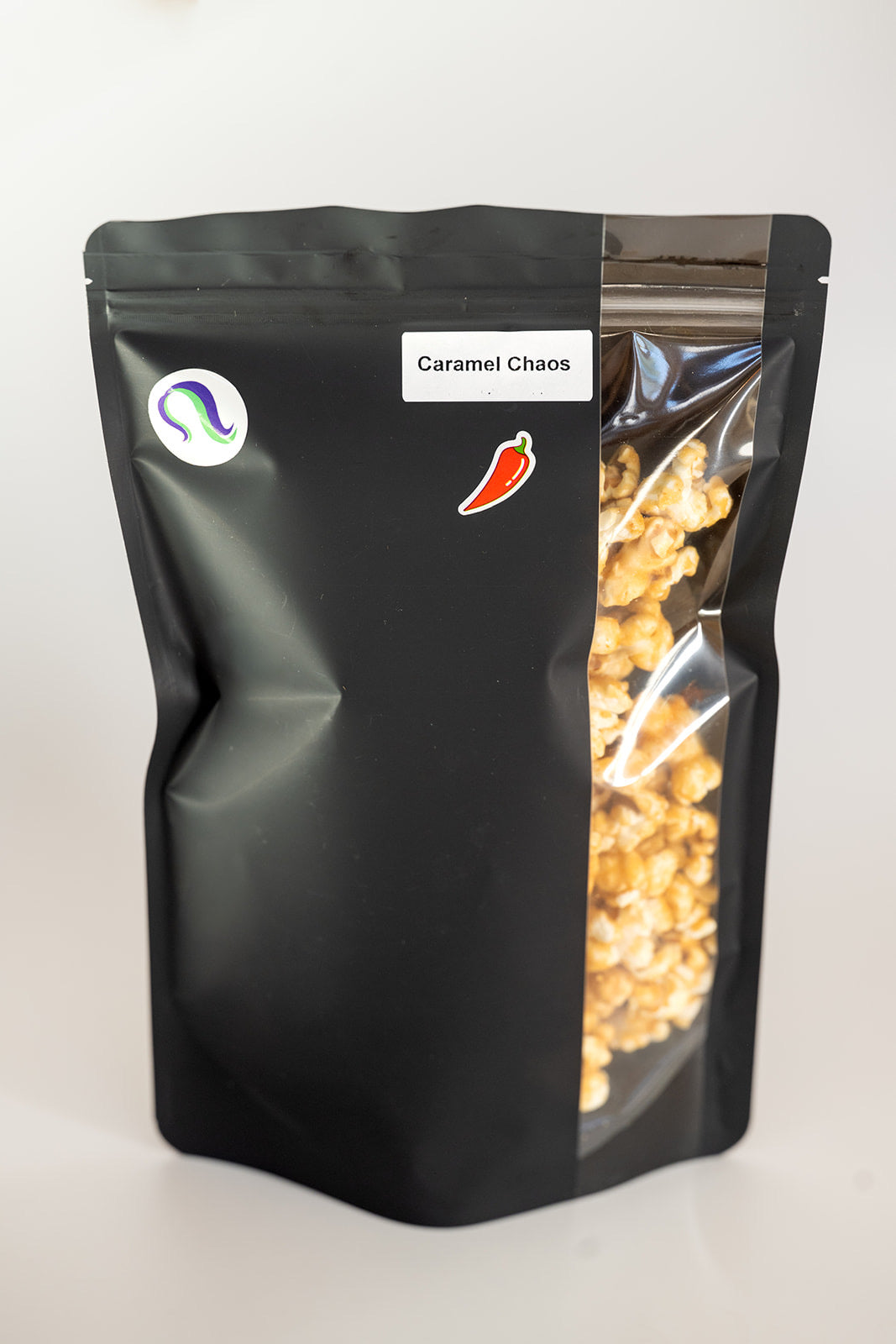 TBC Creations Caramel Chaos spicy popcorn large bag with side window view and chili pepper sticker